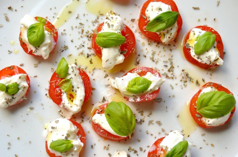 Italian summer food: caprese salad on a white plate, Italian summer food: caprese salad on a white plate. Tomato, burrata cheese or mozzarella, basil leaves on a white background.