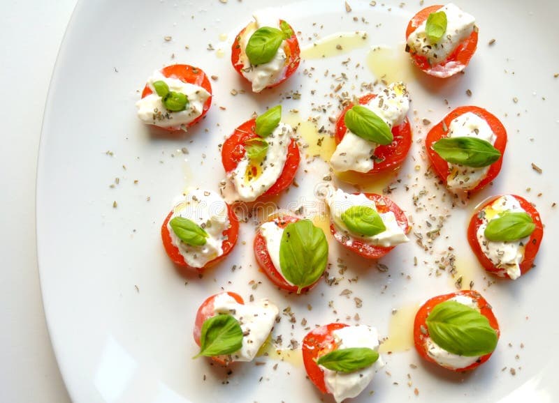 Italian vegetarian food: caprese salad, Italian food: caprese salad on a white plate. Tomato, burrata cheese or mozzarella, basil leaves on a white background.