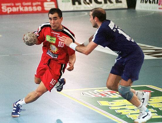 Talant Duishebaev mit Ball attackiert Handball 1. BL Herren Saison 1997 1998: TuS Nettelstedt - SG VfL BHW Hameln Gruppe Dynamik, Kampf,