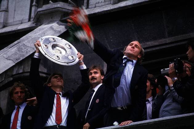 Fußball, FC Bayern München, Deutscher Meister 1985 Die Bayern feiern die Meisterschaft 1985: Klaus Augenthaler präsentiert den Fans die Meisterschale, Dieter Hoeneß wirft Blumen in die Menge Fußball 1. BL Herren Saison 1984 1985, Bayern München, Meisterfeier, Landesmeister, Gruppe Marienplatz München Freude,