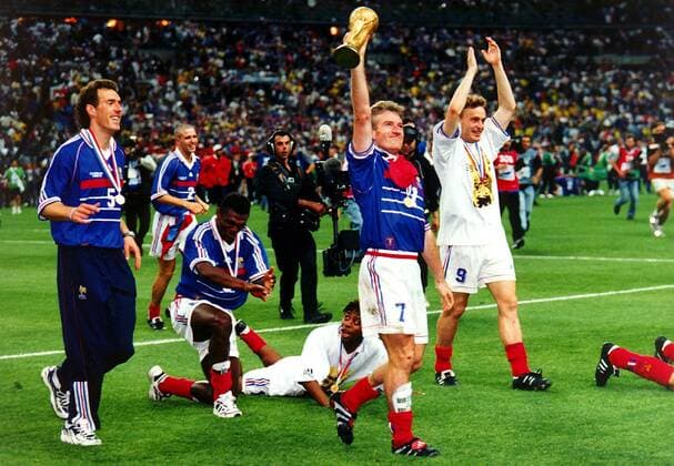 Stolz präsentieren Laurent Blanc, Marcel Desailly, Bernard Diomede, Kapitän Didier Deschamps und Stéphane Guivarc h (v.l.) ihren Fans den Weltpokal Fußball WM Herren Weltmeisterschaft 1998, Länderspiel, Nationalmannschaft, Nationalteam, Nationaltrikot Gruppe Stade de France Paris, Saint Denis Begeisterung, Freude,