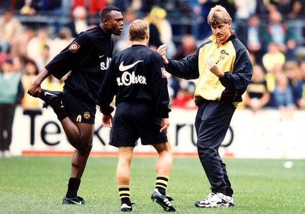 Trainer Michael Skibbe (re.) im Gespräch mit Bachirou Salou (li.) und Thomas Häßler Fußball 1. BL Herren Saison 1998 1999: BVB Borussia Dortmund Gruppe Westfalenstadion Dortmund Nachdenklichkeit,