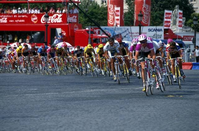 Das Fahrerfeld flitzt um die Kurve, ein Telekom-Fahrer in Führung Radsport Herren Tour de France 1995, Straßenradsport, Straßenradrennsport, Radrennsport, Straße, Rad, Radrennen Totale Dynamik, Kampf,