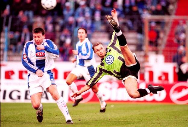 Christian Wück (VfL, re.) mit einem Seitfallzieher, bei dem sich Timo Lange abduckt Fußball 1. BL Herren Saison 1999 2000, FC Hansa Rostock - VfL Wolfsburg 1:1 Gruppe Ostseestadion Rostock Dynamik,
