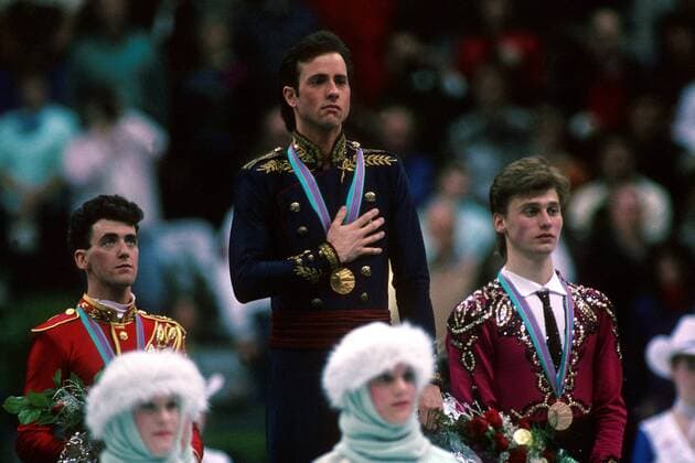 OLYMPIC LEGENDS: Brian Boitano Brian Boitano (USA, Mitte) gerührt bei der Hymne seines Landes, daneben Brian Orser (Kanada, li.) und Viktor Petrenko (Sowjetunion) Eiskunstlauf OS Winter Herren Olympische Winterspiele 1988, Olympia, Olympiade, Spiele, Eiskunstlaufen Gruppe Saddledome Calgary