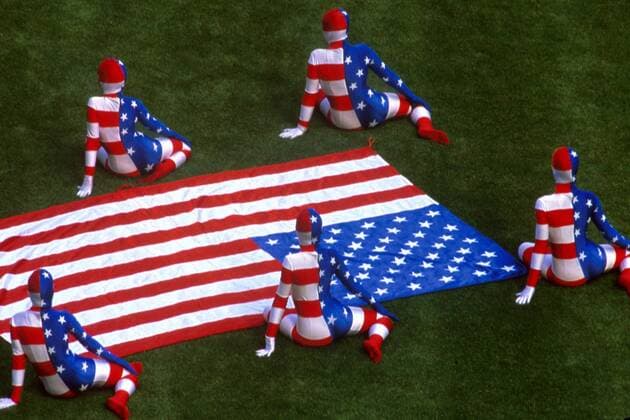 In Stars and Stripes kostümierte Teilnehmer der Eröffnungszeremonie sitzen neben der amerikanischen Nationalfahne Fußball WM Herren Weltmeisterschaft 1994, Eröffnungsfeier, Eröffnung, Zeremonie, Show Gruppe Soldier Field Chicago