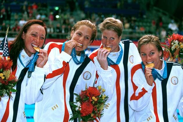 Amy van Dyken (v.l.), Dara Torres, Courtney Shealy und Jenny Thompson (alle USA) prüfen die Echtheit ihrer Goldmedaillen Schwimmen OS Sommer Damen Olympische Sommerspiele 2000, Olympia, Olympiade, Spiele, Schwimmsport, 4 x 100 m Freistil Staffel Gruppe Aquatic Centre Sydney Freude,