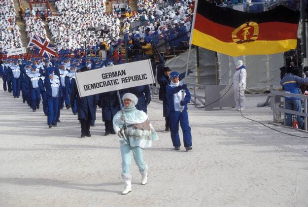 Frank Peter Rötsch (DDR) führt als Fahnenträger die DDR-Olympiamannschaft ins Stadion Biathlon OS Winter Herren Olympische Spiele 1988, Winterspiele, Olympia, Olympiade, Eröffnung, Eröffnungsveranstaltung, Feier Totale Ski nordisch Nordischer Skisport Calgary