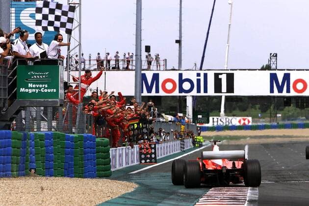 Michael Schumacher (Deutschland) passiert im Ziel die jubelnde Ferrari-Crew Motorsport Grand Prix Herren Großer Preis von Frankreich 2002, Formel 1 Weltmeisterschaft, F1, F, GP, WM, Vdig Totale Circuit de Nevers Magny Cours Freude, Begeisterung