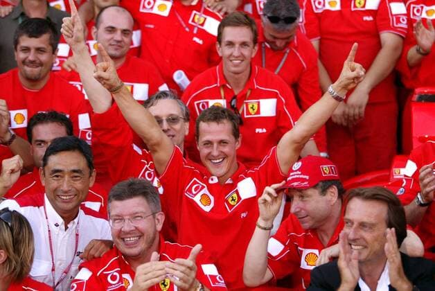Weltmeister Michael Schumacher (Deutschland Ferrari) jubelnd inmitten seines Teams, vorn v.li.: Technikdirektor Ross Brawn (England), Teamchef Jean Todt (Frankreich) und Ferrari-Präsident Luca di Montezemolo (Italien) Motorsport Grand Prix Herren Großer Preis von Frankreich 2002, Formel 1 Weltmeisterschaft, F1, F, GP, WM, Vdig Gruppe Circuit de Nevers Magny-Cours Freude, Begeisterung,
