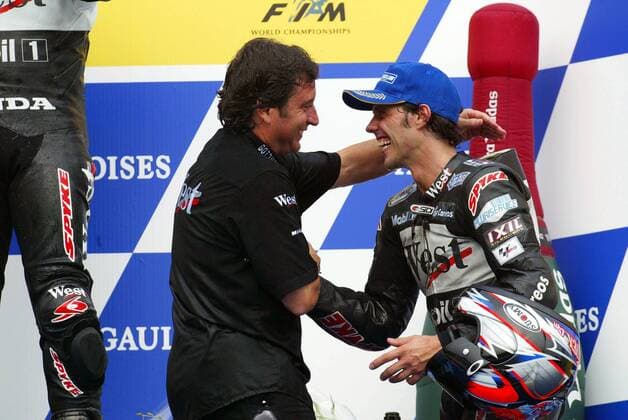 Teammanager Alfonso Sito Pons (li., Spanien) gratuliert Loris Capirossi (Italien beide Honda-Pons) zum dritten Platz Motorsport WM Herren Weltmeisterschaft 2002, Motorrad, Motorradrennen, Motorradrennsport, Motorradsport Gruppe Motegi Freude,