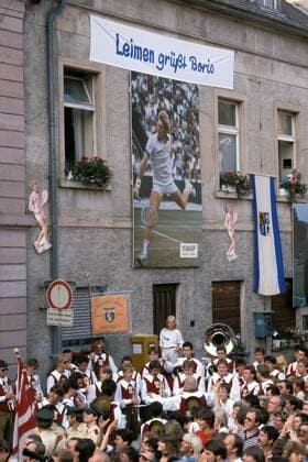 Plakat von Boris Becker (Deutschland) thront über dem Karneval-Club e.V. Nussloch der zum Empfang des Wimbledon-Siegers in Leimen musiziert Tennis Herren All England Championships 1985, Vdia, Heimatstadt Totale Leimen