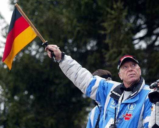 Bundestrainer Reinhard Hess (Deutschland) mit der Landesfahne Skispringen Herren 51. Vierschanzentournee 2002 2003, Vierschanzen-Tournee, Schanzentournee Einzelbild Qualifikation Oberstdorf, Startzeichen