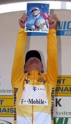 Gesamtsieger Alexander Vinokourov (Kasachstan Team Deutsche Telekom) ehrt seinen tödlich verunglückten Landsmann Andrei Kivilev während der Siegerehrung mit einem Foto Radsport Herren 70. Paris - Nizza 2003, Radrennsport, Straßenradsport, Straßenradrennsport, Radrennen, 7. Etappe Einzelbild Sieg, Sieger, Gesamtsieg, Fotografie, Ehrung Nizza, Unglück, tödlicher Unfall, verunglückt Kameradschaft,
