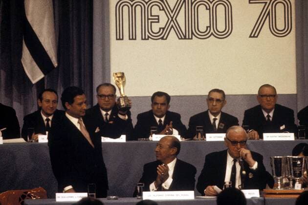 FIFA-Vizepräsident Guillermo Caneda (li.) präsentiert während der Gruppenauslosung den Coupe Jules Rimet, der Bürgermeister von Mexico-City Alfonso Corona del Rosal (Mitte, beide Mexiko) applaudiert, daneben FIFA-Präsident Sir Stanley Rous (England) Fußball WM Herren Auslosung der Gruppen für die Weltmeisterschaft 1970, Versammlung, Sitzung, Tagung, auslosen Gruppe Aufnahmedatum geschätzt Mexico-Stadt, Weltmeisterschaftspokal
