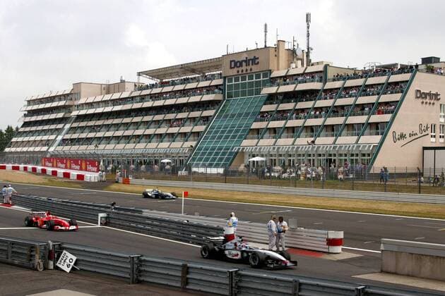 Während Ralf Schumacher (hinten, Deutschland BMW-Williams) im Qualifying seine schnelle Runde absolviert, stehen Kimi Räikkönen (vorn, Finnland McLaren-Mercedes) und Michael Schumacher (Deutschland Ferrari) an der Boxenausfahrt bereit Motorsport Grand Prix Herren Großer Preis von Europa 2003, Formel 1 Weltmeisterschaft, F1, F, GP, WM, Vdig Totale Nürburgring Nürburg