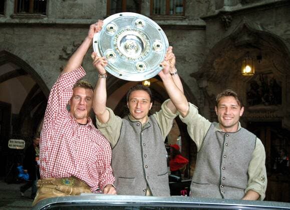Fußball, FC Bayern München, Deutscher Meister 2003 V.li.: Alexander Zickler, Nico und Robert Kovac (alle Bayern) präsentieren in traditionellen bayerischen Trachten die Meisterschaftsschale von einem Auto aus Fußball 1. BL Herren Saison 2002 2003, FC Bayern München, Deutscher Meister, Deutsche Meisterschaft, Meisterfeier, Feier Gruppe Marienplatz, Rathausplatz München Freude,
