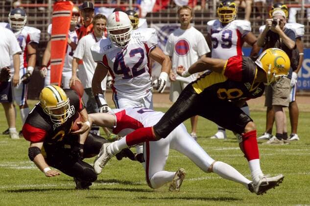 Running Back Dominique Kuhn (Deutschland, li.) wird von Defensive Back Emmanuel Charret (Frankreich) gestoppt American Football WM Herren Weltmeisterschaft 2003, Spiel um den dritten Platz, Länderspiel, Deutschland - Frankreich 36:7 Gruppe Hanau Dynamik, Kampf,
