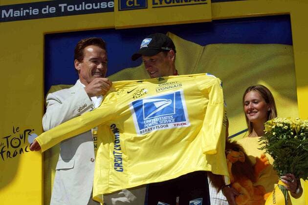 Hollywood-Schauspieler Arnold Schwarzenegger (Österreich, li.) streift Lance Armstrong (USA US Postal Service) das gelbe Trikot über Radsport Herren Tour de France 2003, Straßenradsport, Straße, Rad Gruppe 11. Etappe: Narbonne - Toulouse  