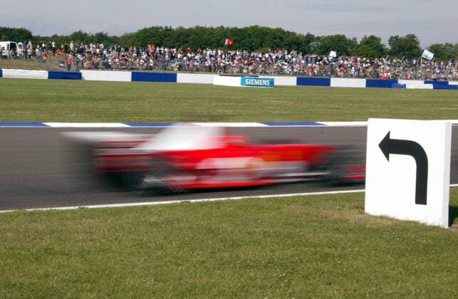Der Pfeil zeigt nach links, doch Michael Schumacher (Deutschland) rast in seinem Ferrari full speed geradeaus Motorsport Grand Prix Herren Großer Preis von England 2003, Formel 1 Weltmeisterschaft, F1, F, GP, WM, Qualifying Einzelbild Silverstone Dynamik,