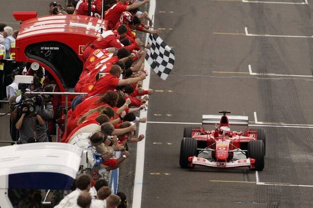Rubens Barrichello (Brasilien Ferrari) fährt im Ziel an dem jubelnden Ferrari-Team vorbei Motorsport Grand Prix Herren Großer Preis von England 2003, Formel 1 Weltmeisterschaft, F1, F, GP, WM, Totale Silverstone