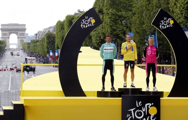 Gesamtsieger Lance Armstrong (Mitte, USA US Postal Service) im Gelben Trikot während der Nationalhymne auf den Champs Elysee mit dem Zweiten Jan Ullrich (li., Deutschland Bianchi) und dem Dritten Alexander Winokurow (re., Kasachstan Telekom) Radsport Herren Tour de France 2003, Straßenradsport, Rad, Straße, Totale Arc de Triomphe Paris, 20. Etappe