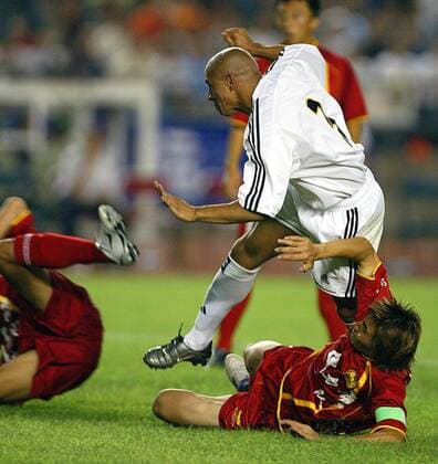 Roberto Carlos (Real) setzt sich gegen seine Gegenspieler vom Dragon Team durch Fußball Herren Saisonvorbereitung 2003 2004, Real Madrid, Test, Testspiel Gruppe Peking Dynamik, Kampf,