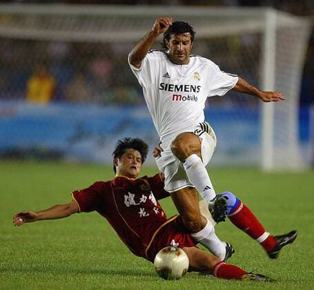 Luis Figo (vorn, Real) setzt sich gegen seinen Gegenspieler vom Dragon Team durch Fußball Herren Saisonvorbereitung 2003 2004, Real Madrid, Test, Testspiel Gruppe Peking Dynamik,