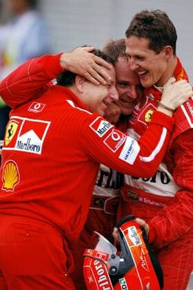 Erfolgstrio: Weltmeister Michael Schumacher (Deutschland, re.) drückt Teamchef Jean Todt (Frankreich, li.) und Sieger Rubens Barrichello (Brasilien, alle Ferrari) fest an sich Motorsport Grand Prix Herren Großer Preis von Japan 2003, Formel 1 Weltmeisterschaft, F1, F, GP, WM Gruppe Suzuka Glück, Freude,