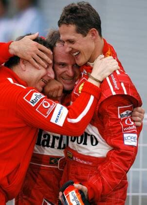 Erfolgstrio: Weltmeister Michael Schumacher (Deutschland, re.) drückt Teamchef Jean Todt (Frankreich, li.) und Sieger Rubens Barrichello (Brasilien, alle Ferrari) fest an sich Motorsport Grand Prix Herren Großer Preis von Japan 2003, Formel 1 Weltmeisterschaft, F1, F, GP, WM Gruppe Suzuka Glück, Freude, Begeisterung,