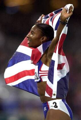 Großbritannien, Black History Month im Oktober - Sport Olympiasiegerin Denise Lewis (Großbritannien) ist mit ihrer Landesfahne auf der Ehrenrunde Leichtathletik OS Sommer Damen Olympische Sommerspiele 2000, Spiele, Olympia, Olympiade, Nationaltrikot, Einzelbild Sydney Freude,