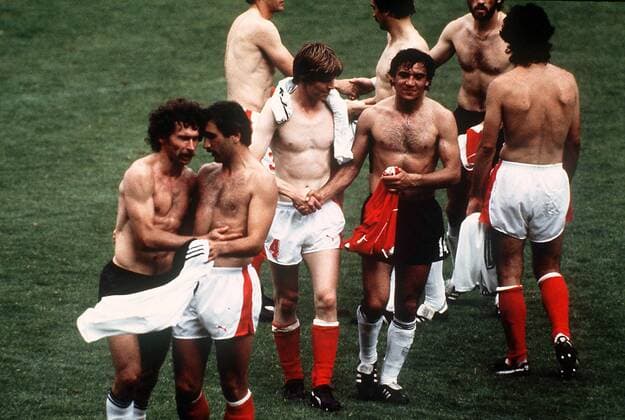 IMAGO Iconic Moments, Fußball Trikottausch der Akteure nach dem Skandalspiel von Gijon - v. li.: Paul Breitner (Deutschland), Hans Krankl, Josef Degeorgi (beide Österreich) und Felix Magath Fußball WM Herren Weltmeisterschaft 1982, Länderspiel, Gruppenspiel, Gruppe 2, Nationalmannschaft, Nationalteam Gruppe Spielabsprache, unsportlich, Unsportlichkeit
