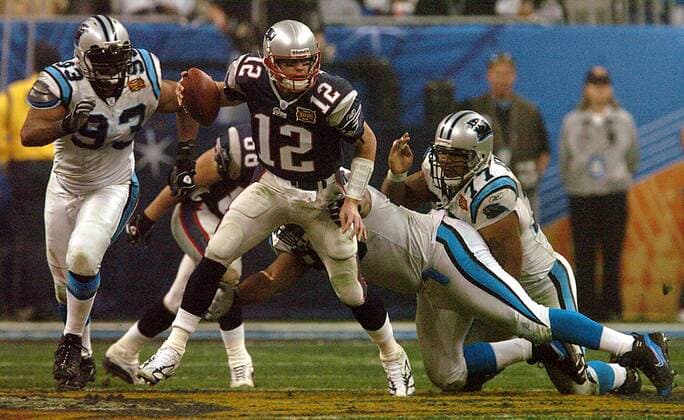 Quarterback Tom Brady (New England Patriots, Mitte) kann Defensive End Mike Rucker (li.) und Defensive Tackle Kris Jenkins (beide Carolina Panthers) mit der Pille entkommen American Football Herren NFL 2003 2004, Super Bowl XXXVIII, Superbowl, New England Patriots - Carolina Panthers 32:29, Vdig Gruppe Houston Dynamik,  