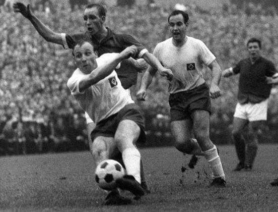 Uwe Seeler (vorn, HSV) setzt sich gegen Willi Schulz (Mitte, Schalke) durch, dahinter Hubert Stapelfeldt (HSV) Fußball 1. BL Herren Saison 1963 1964, FC Schalke 04 - Hamburger SV 1:0 Gruppe Gelsenkirchen Dynamik,