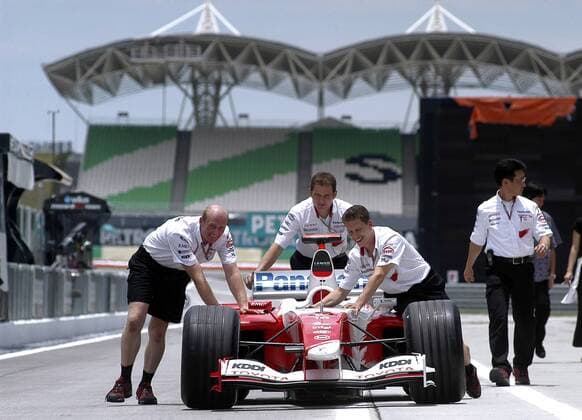 Mechaniker schieben gut gelaunt einen Toyota durch die Boxengasse Motorsport Grand Prix Herren Großer Preis von Malaysia 2004, Formel 1 Weltmeisterschaft, F1, F, GP, WM, Vdig Gruppe Sepang Kuala Lumpur Freude