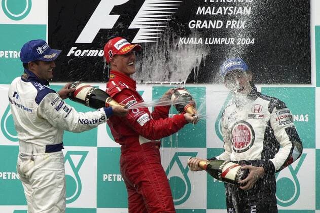 Siegerehrung GP Malaysia 2004, v.li.: Juan-Pablo Montoya (Kolumbien BMW-Williams), Michael Schumacher (Deutschland Ferrari) und Jenson Button (England BAR-Honda) feiern mit einer Sektdusche Motorsport Grand Prix Herren Großer Preis von Malaysia 2004, Formel 1 Weltmeisterschaft, F1, F, GP, WM Gruppe Sepang Kuala Lumpur Freude, Begeisterung,