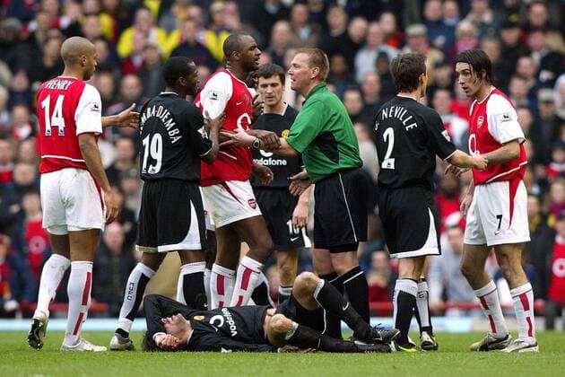 Schiedsrichter Graham Poll beruhigt die Gemüter während Ruud van Nistelrooy verletzt am Boden liegt; Eric Djemba-Djemba (2.v.li.) und Gary Neville (alle Manchester United) geraten an Thierry Henry, Patrick Vieira und Robert Pires (v.li., alle Arsenal) Fußball Herren English Premier League 2003 2004, 1. Englische Liga, Arsenal FC London - Manchester United 1:1, ManU Gruppe London