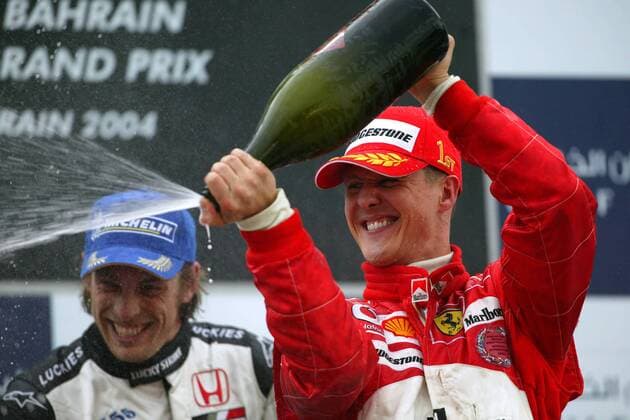 Siegerehrung GP Bahrain 2004: Michael Schumacher (Deutschland Ferrari, re.) feiert mit Ersatz-Champagner, li. Button (England BAR-Honda) Motorsport Grand Prix Herren Großer Preis von Bahrain 2004, Formel 1 Weltmeisterschaft, F1, F, GP, WM Gruppe Bahrain Racing Circuit Manama Freude, Begeisterung,
