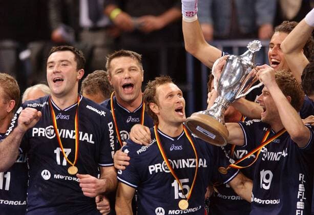 Die Titelverteidiger v. li.: Andrej Klimovets, Co-Trainer Bogdan Wenta, Lars Christiansen und Sören Stryger bejubeln den Pokalsieg Handball 1. BL Herren DHB-Pokal 2003 2004, Pokalspiel, Top Four Turnier, Pokalfinale, Finale, Endspiel, Pokalendspiel Gruppe Andrei, Andreij, Klimowets, Hamburg, Gold, Goldmedaille, Goldmedaillen, Begeisterung, Freude,