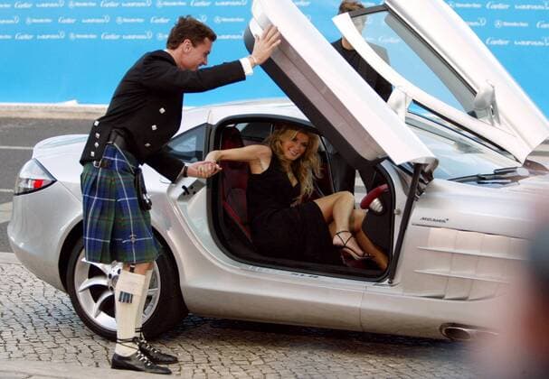 David Coulthard (Schottland) hilft Topmodel Marisa Miller bei ihrer Ankunft zur Verleihung des Laureus World Sports Awards 2004 aus dem McLaren Motorsport Herren Laureus World Sports Awards 2004, Sportlerwahl, Ehrung, Sportlerehrung, Sportlerauszeichnung, Vdig Gruppe Model, Auto, Sportwagen, Mercedes, Award Estoril, Gentleman
