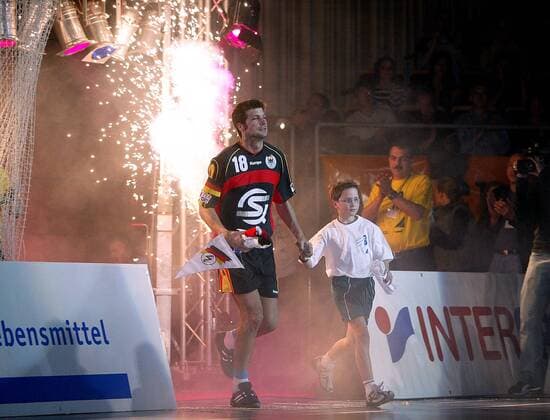 Daniel Stephan (Deutschland) wird bei seinem pompösen Einmarsch von einem Kind begleitet Handball Herren Nationalmannschaft 2004, Nationalmannschaft, Nationalteam, Nationaltrikot Gruppe Saarbrücken