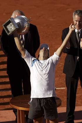Gaston Gaudio (Argentinien) streckt triumphierend die Siegertrophäe der French Open 2004 in die Luft Tennis Herren French Open 2004, Grand Slam, ATP-Tour, Sand, Sandplatz, Sandplatztennis, Sandplatzturnier, Vdig, Gruppe Roland Garros Paris Begeisterung, Freude,