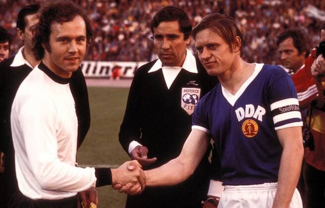 Franz Beckenbauer (li., BR Deutschland) und Bernd Bransch (DDR) begrüßen sich zur Seitenwahl, dazwischen Schiedsrichter Ramon Barreto (Uruguay) Fußball WM Herren Weltmeisterschaft 1974, Länderspiel, Gruppenspiel, Gruppe 1, Nationalmannschaft, Nationalteam Gruppe DDR - BRD 1:0 Hamburg