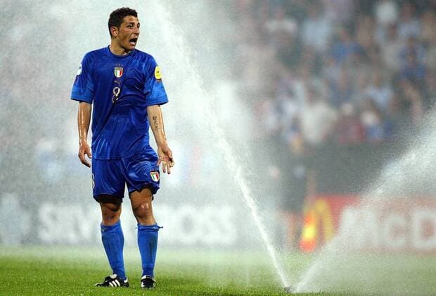 Angelo Palombo (U21 Italien) beschwert sich über die unfreiwillige Dusche Fußball EM Herren U 21 Europameisterschaft 2004, Nationalmannschaft, Nationalteam, Nationaltrikot, Einzelbild Aufmacher, Sprinkleranlage, Bewässerungsanlage Bochum, Sprinkler, Versenkregner, Bewässerung