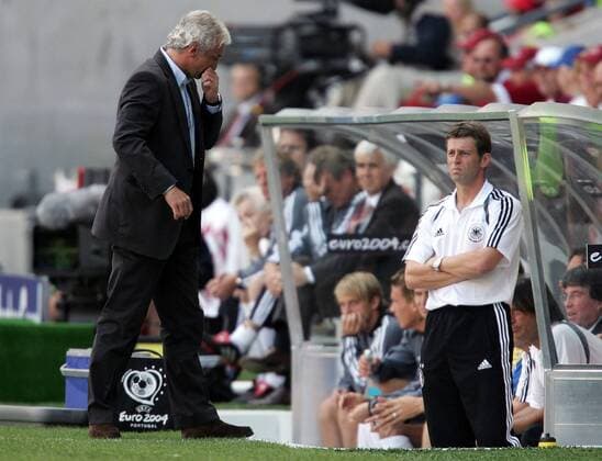Teamchef Rudi Völler (li.) fasst sich an die eigene Nase, Bundestrainer Michael Skibbe (beide Deutschland) bleibt skeptisch Fußball EM Herren Euro 2004, Europameisterschaft, Länderspiel, Nationalmannschaft, Nationalteam, Gruppe D Gruppe Porto Skepsis, Enttäuschung