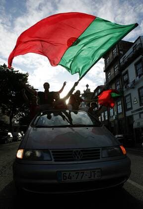 Portugiesische Fans fahren im vollbesetzten Auto durch Porto und feiern den Viertelfinaleinzug Fußball EM Herren Euro 2004, Europameisterschaft, Länderspiel, Nationalmannschaft, Nationalteam, Gruppe A Gruppe Abend, abends, Sonnenuntergang, Emotionen Porto Freude, Begeisterung,