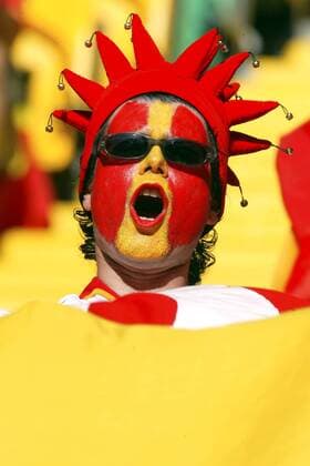 Spanischer Fan mit Narrenkappe und Gesichtsbemalung in den Landesfarben Fußball EM Herren Euro 2004, Europameisterschaft, Länderspiel, Nationalmannschaft, Nationalteam, Gruppe A Porträt Lissabon
