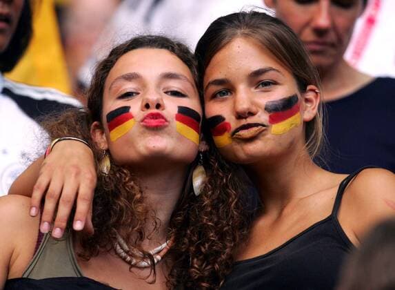 Zwei weibliche deutsche Fans mit Gesichtsbemalung machen einen Kussmund Fußball EM Herren Euro 2004, Europameisterschaft, Länderspiel, Nationalmannschaft, Nationalteam, Gruppe D Gruppe Aufmacher Lissabon Freude, Sinnlichkeit