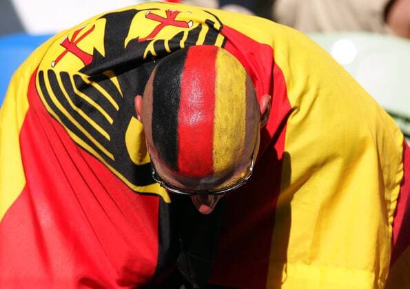 Gesenkten Hauptes: Deutscher Fan mit Kopfbemalung und Deutschlandfahne Fußball EM Herren Euro 2004, Europameisterschaft, Länderspiel, Nationalmannschaft, Nationalteam, Gruppe D Einzelbild Lissabon Enttäuschung, Verzweiflung