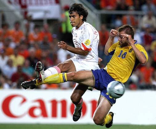 Giovanni van Bronckhorst (Niederlande, li.) gegen Mattias Jonson (Schweden) Fußball EM Herren Euro 2004, Europameisterschaft, Länderspiel, Nationalmannschaft, Nationalteam, Viertelfinale, Gruppe Faro-Loule Dynamik, Kampf,